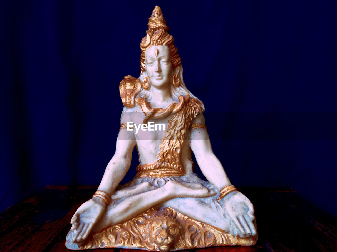 Close-up of buddha statue against blue background