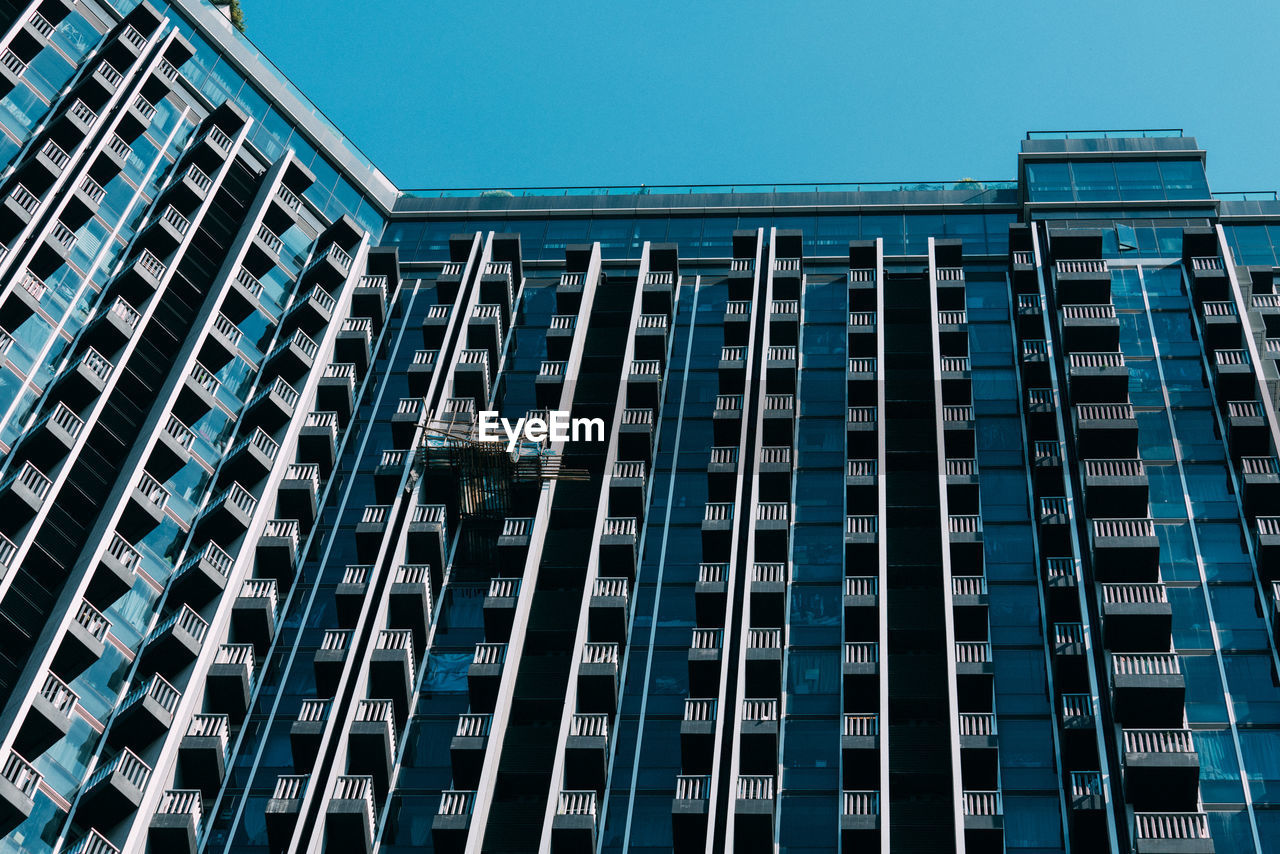 Low angle view of modern building against clear blue sky