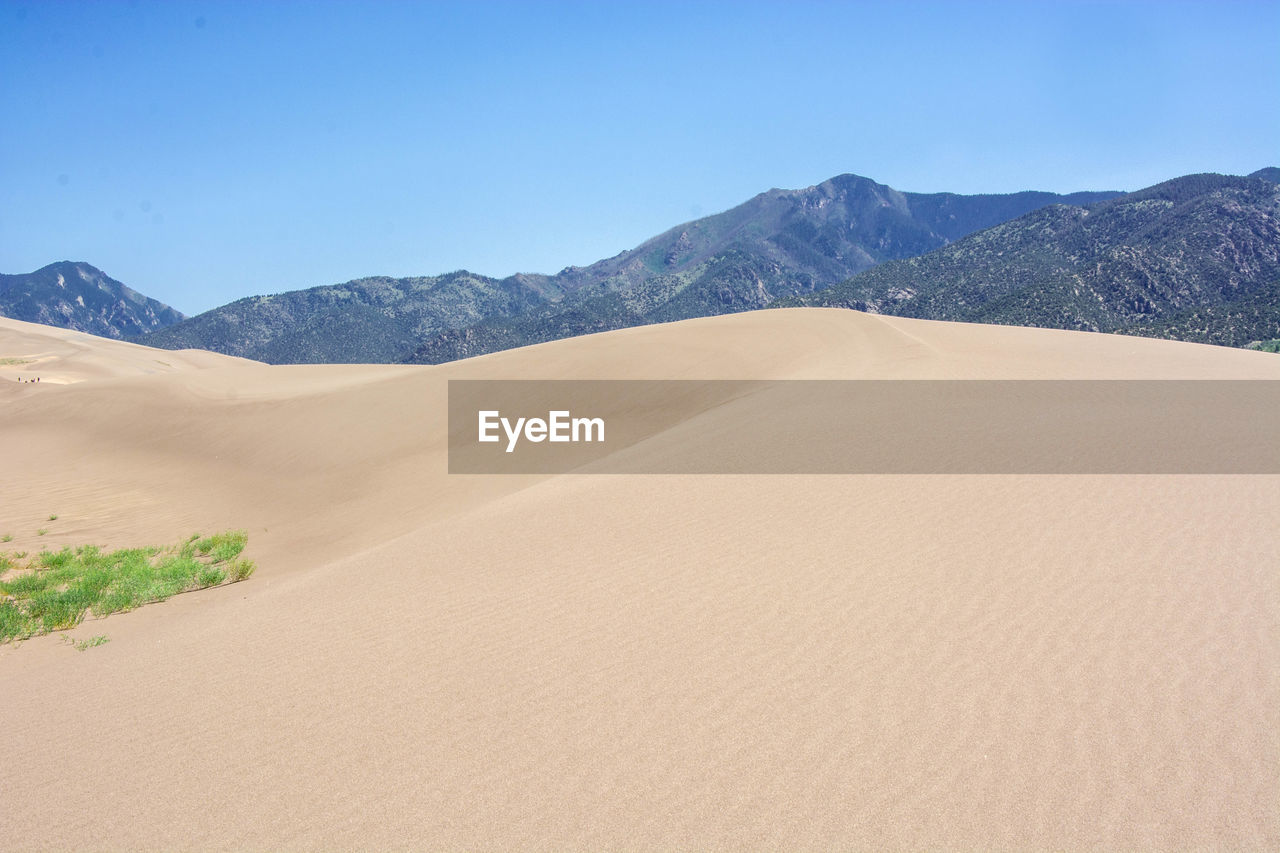 SAND DUNES IN DESERT AGAINST SKY