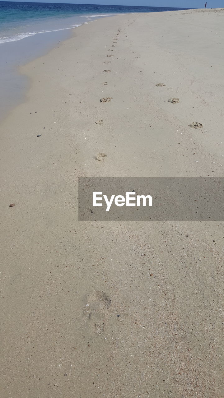 HIGH ANGLE VIEW OF FOOTPRINTS ON WET SHORE