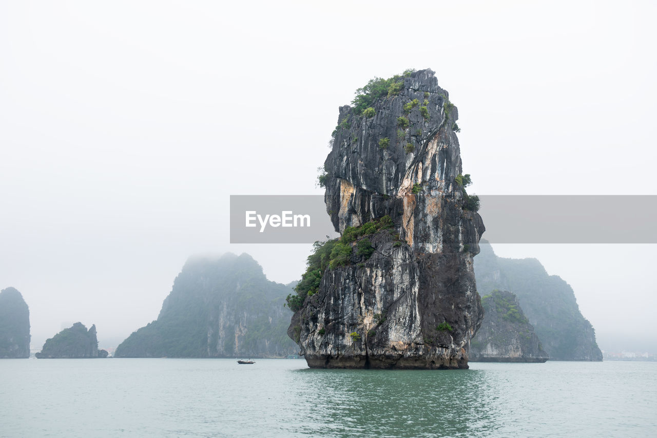 Rock formations in sea against clear sky