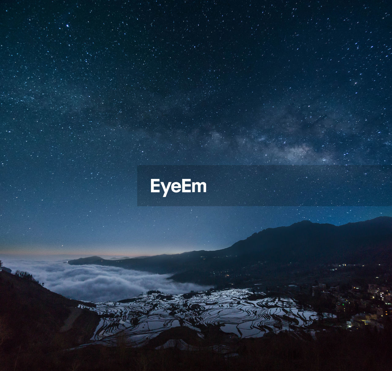 SCENIC VIEW OF SNOWCAPPED MOUNTAINS AGAINST STAR FIELD AT NIGHT