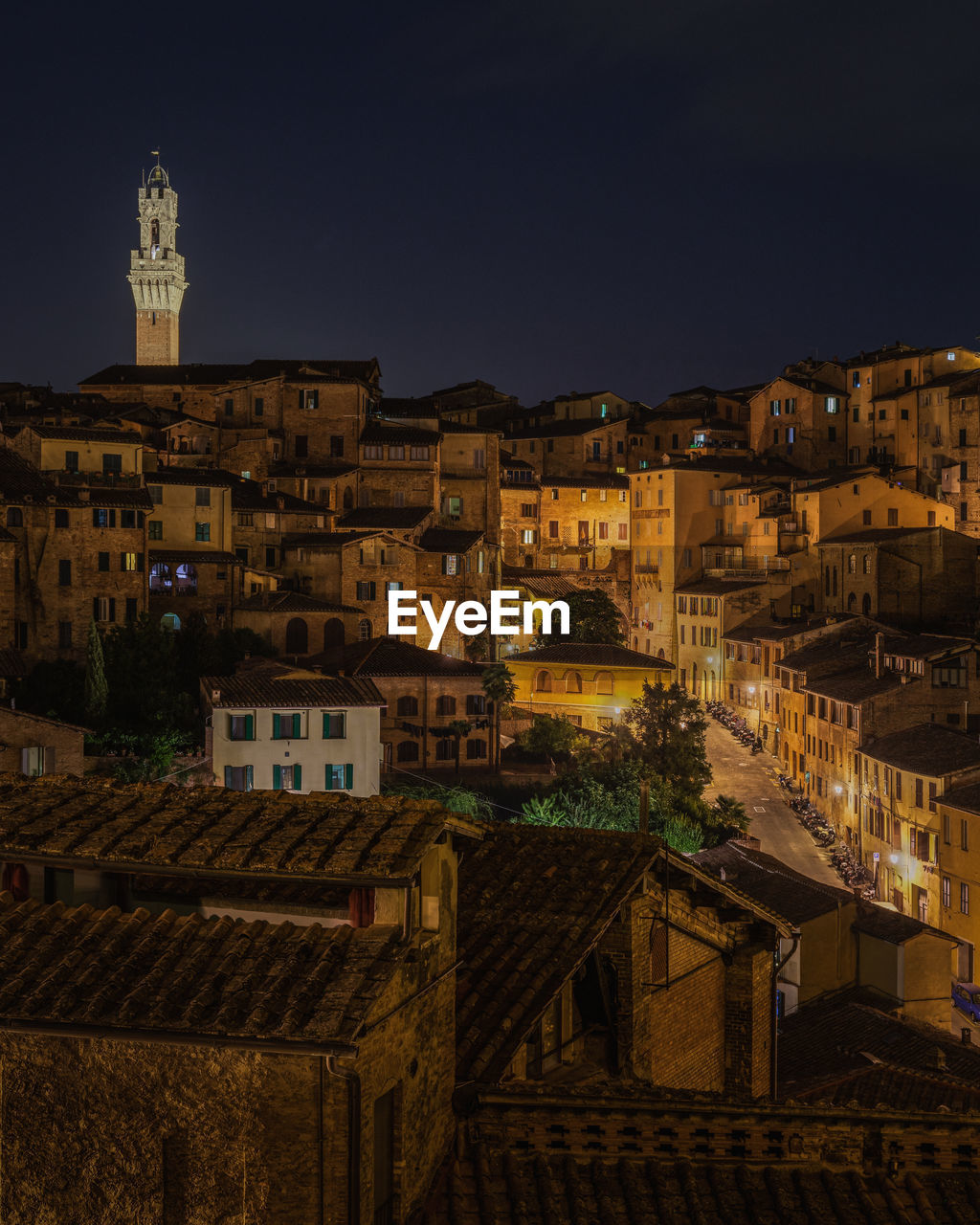 Torre del mangia towering above the historic center of siena at night, tuscany, italy