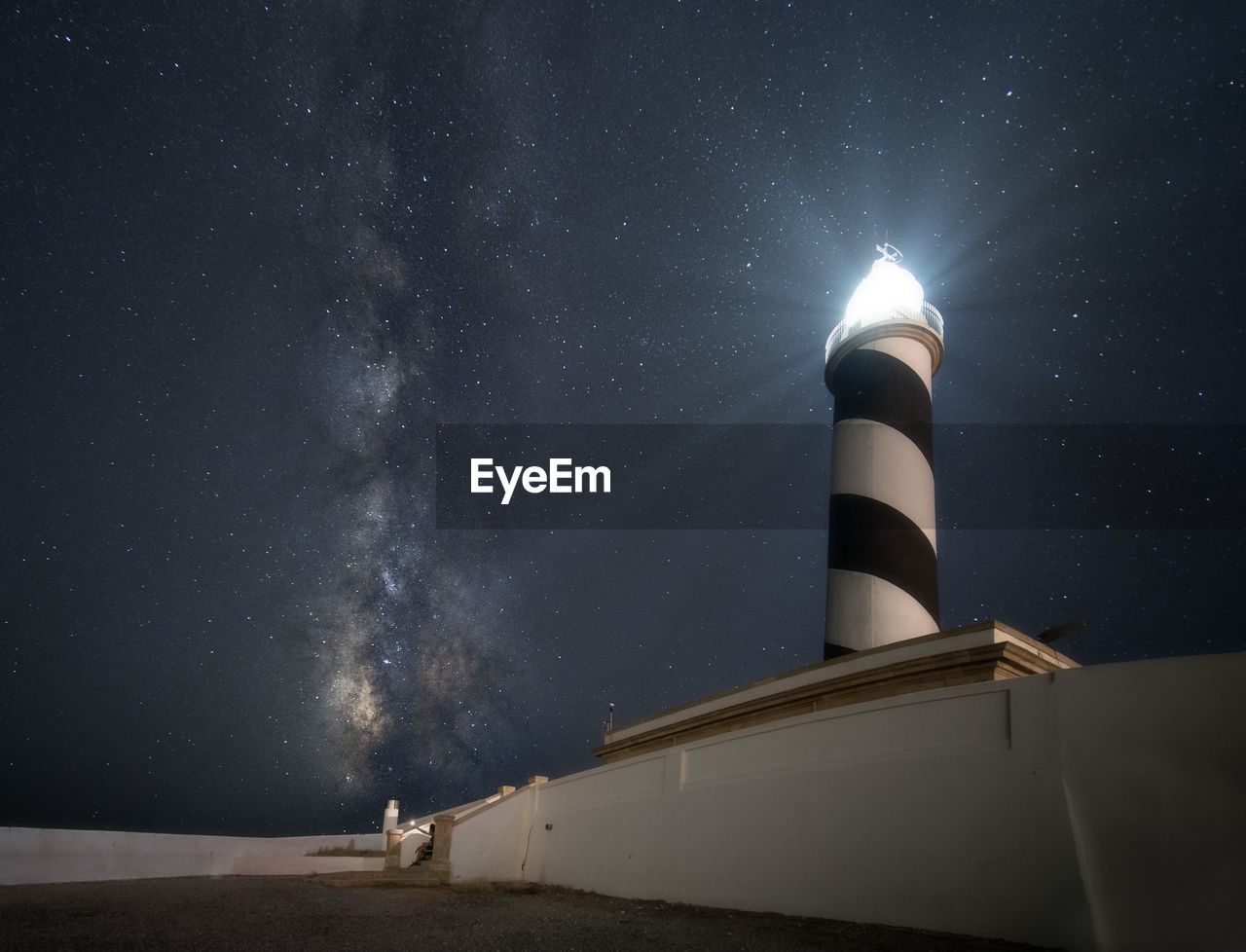 low angle view of lighthouse against blue sky at night