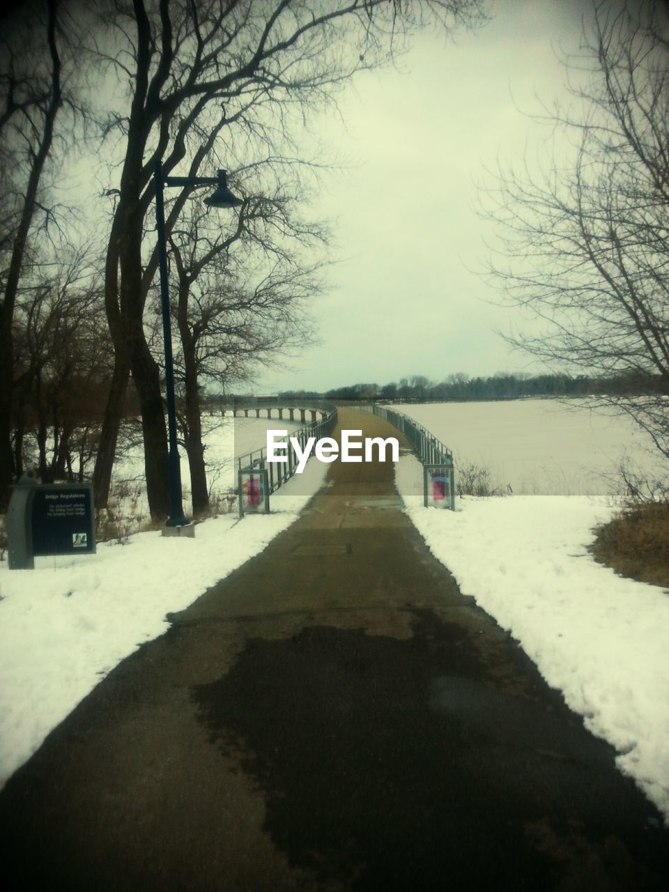 Bridge passing through snow covered landscape