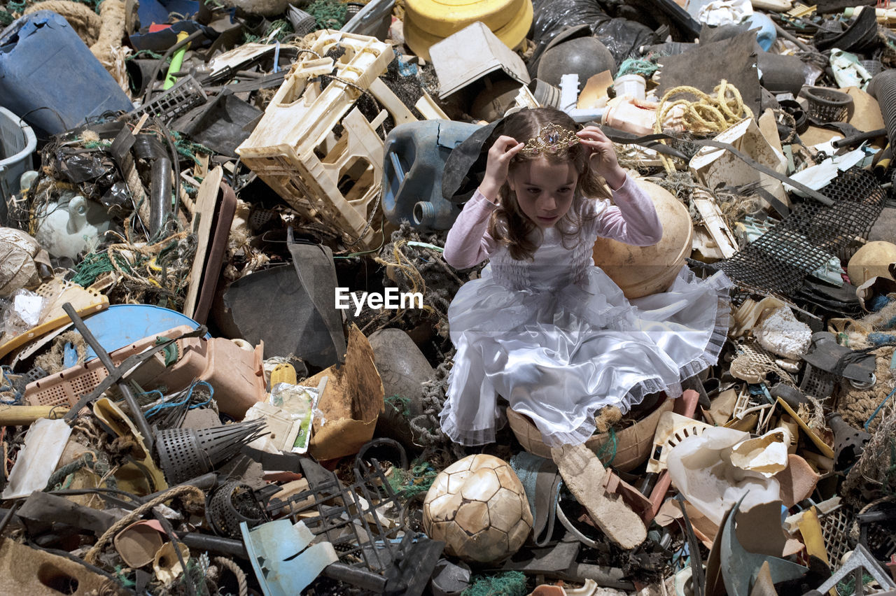 High angle view of girl sitting in garbage