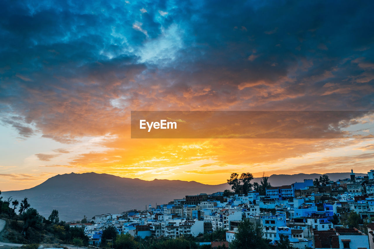 Buildings against cloudy sky during sunset