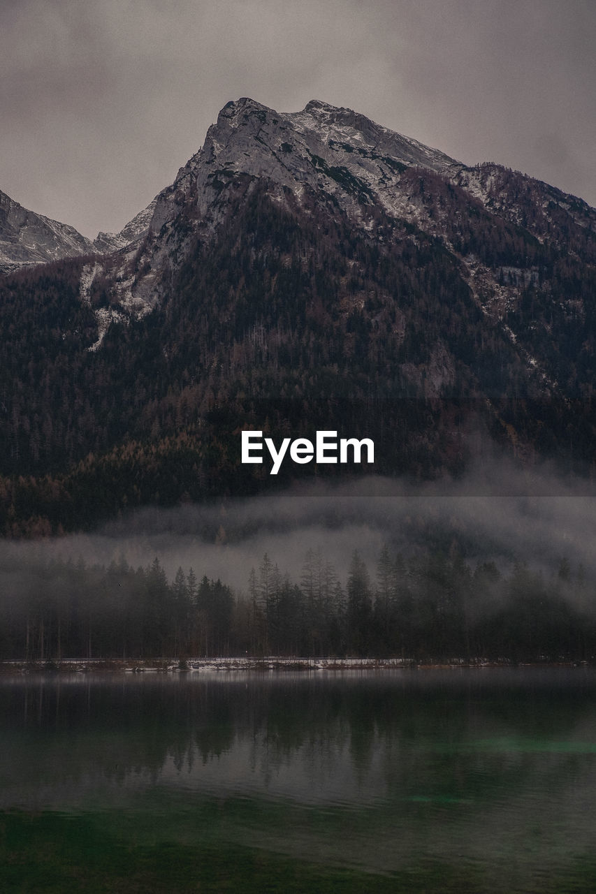 Scenic view of lake by mountain against sky