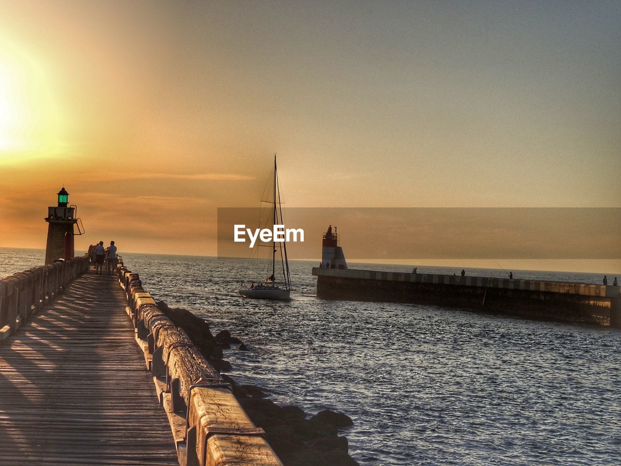 Pier over sea against sky during sunset