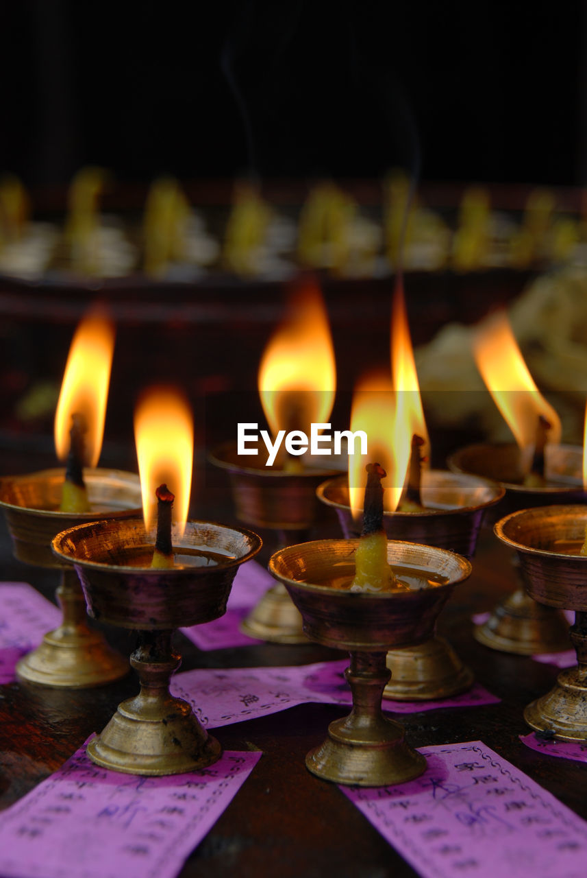 Close-up of burning diyas at temple