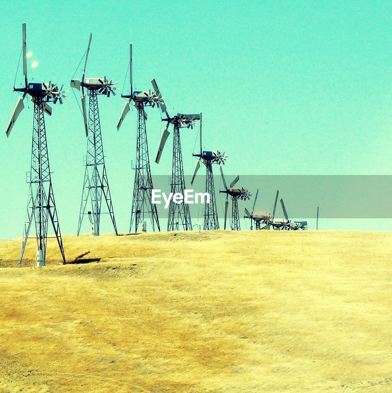 Windmill on landscape against clear sky