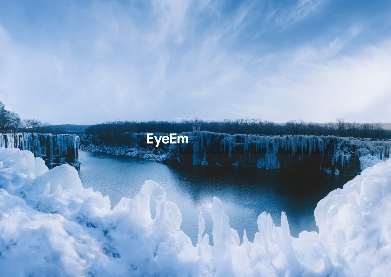 Panoramic view of frozen lake against sky during winter