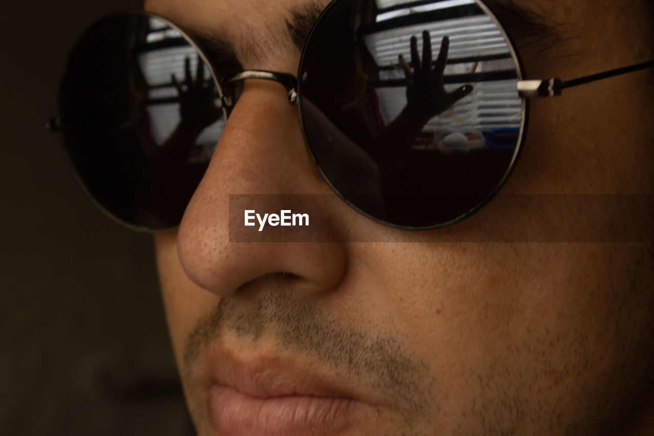 CLOSE-UP OF MAN WEARING SUNGLASSES