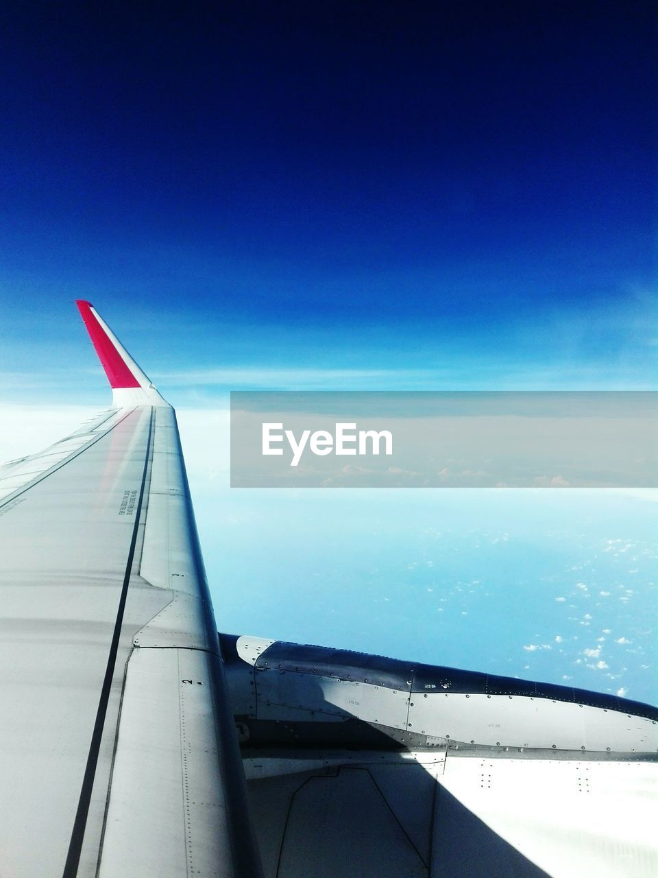 AIRPLANE WING AGAINST CLOUDY SKY