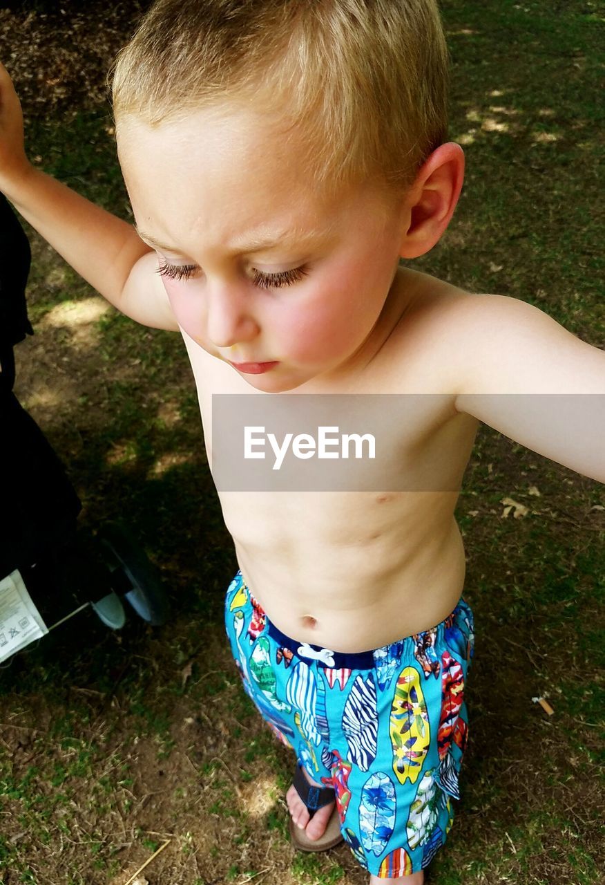 HIGH ANGLE VIEW OF BOY PLAYING ON GRASS AT PARK