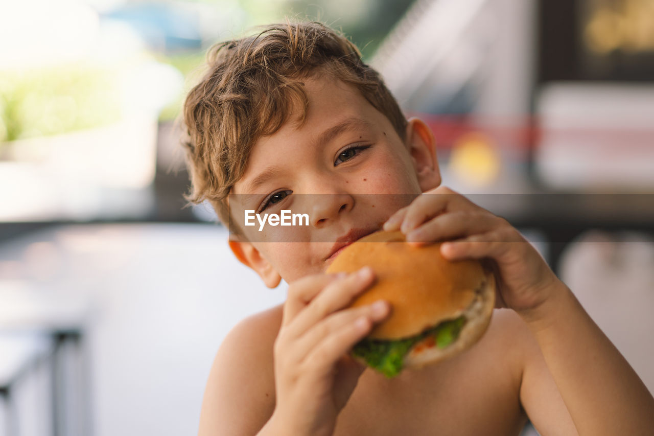 close-up of boy eating food at home