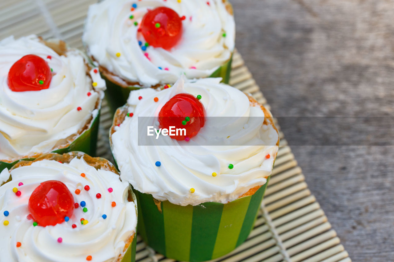 HIGH ANGLE VIEW OF CUPCAKES WITH ICE CREAM ON TABLE