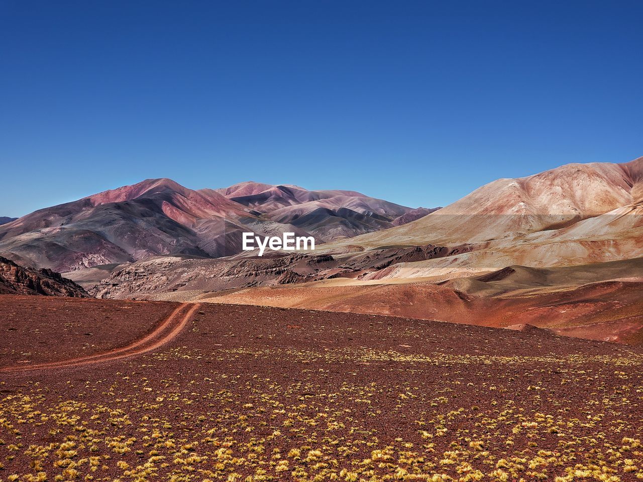 Scenic view of mountains against clear blue sky