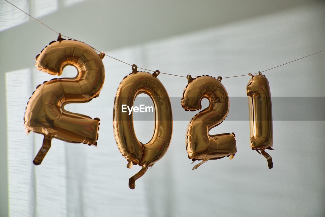 New year's 2021 balloons handing on string indoors. white wall background.