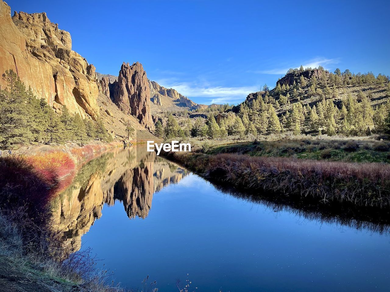 Scenic view of lake and mountains against blue sky