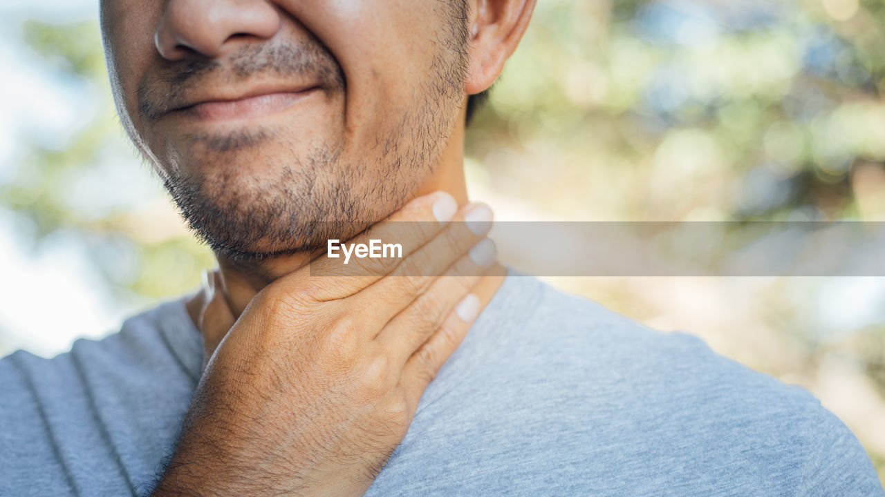 Close-up of man touching neck in pain