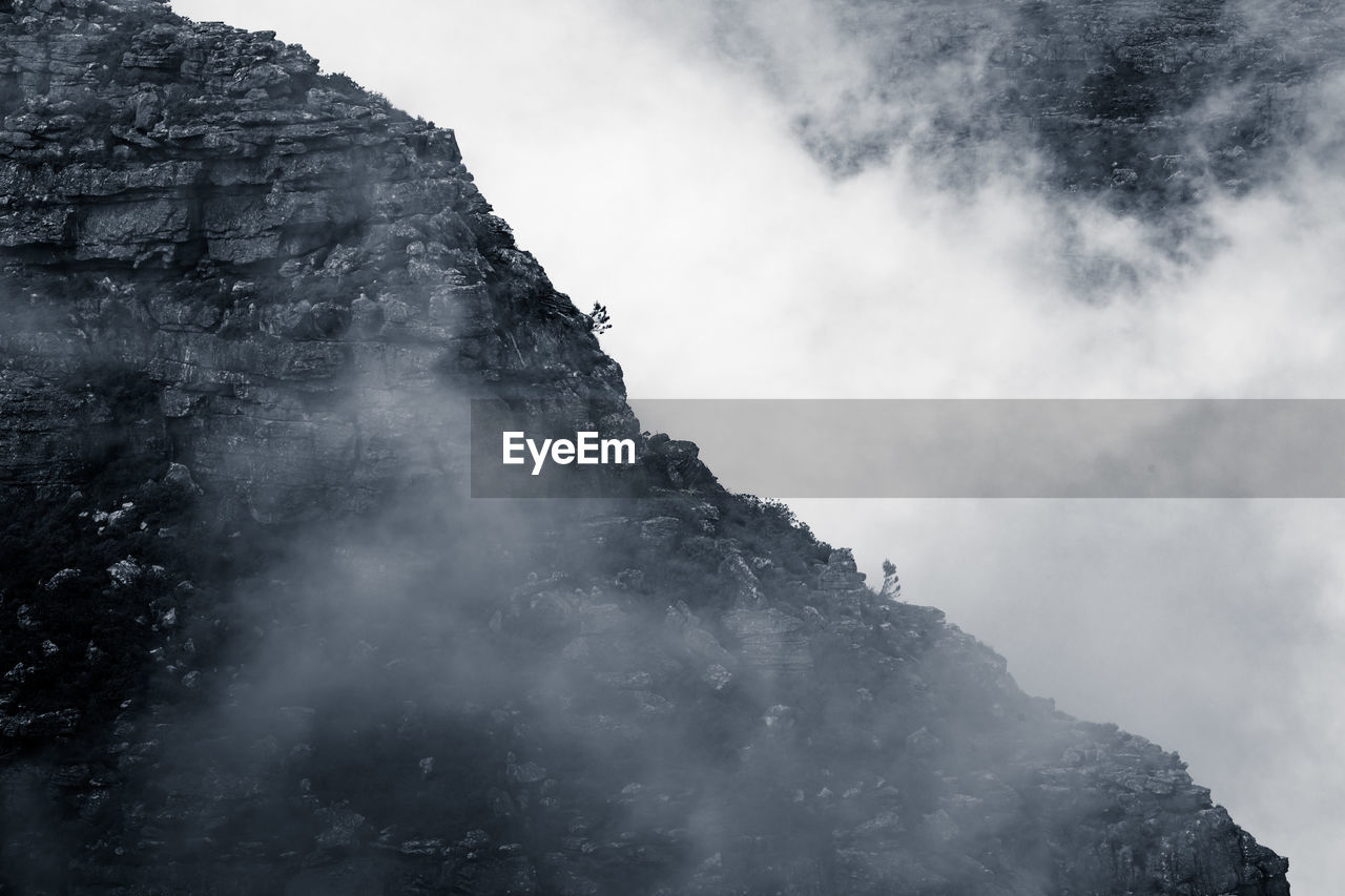 Clouds rolling over table mountain in cape town, southafica. this fenomenon is called tablecloth.