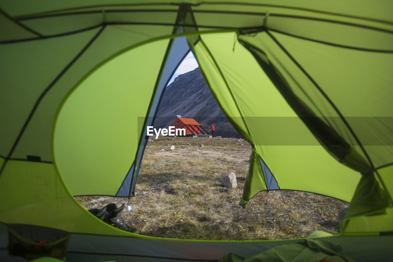 View of emergency shelter and climber through tent door.