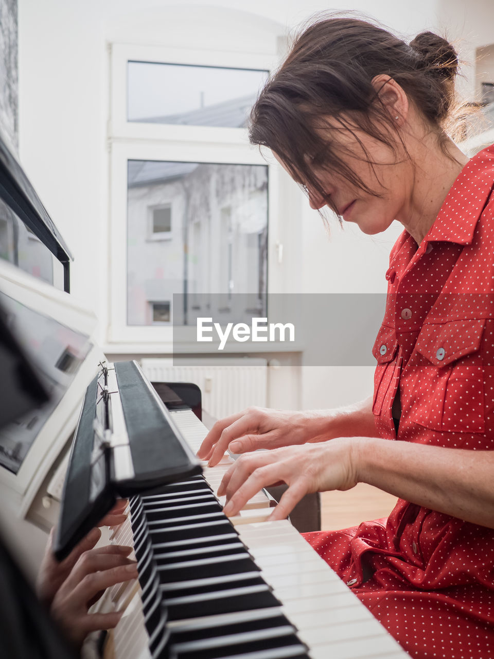 Young woman playing piano at home