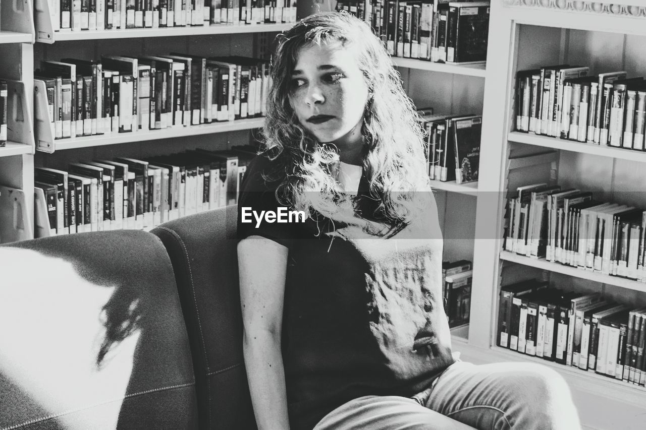 Portrait of young woman sitting in living room