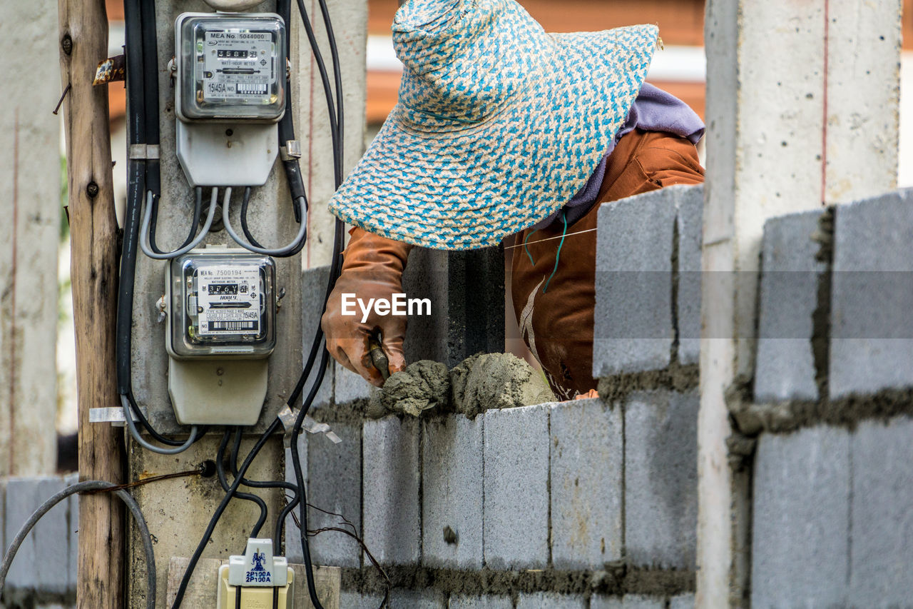 Manual worker wearing hat while working at construction site