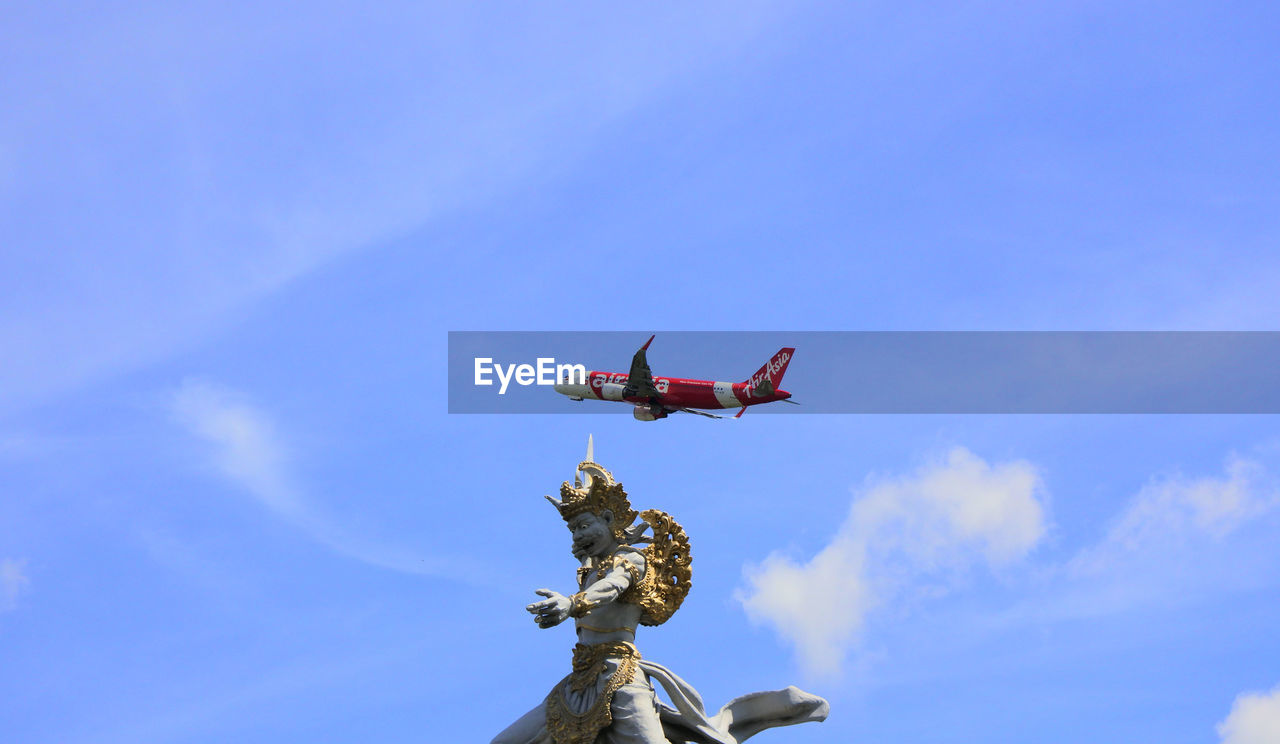 LOW ANGLE VIEW OF AIRPLANE FLYING AGAINST BLUE SKY