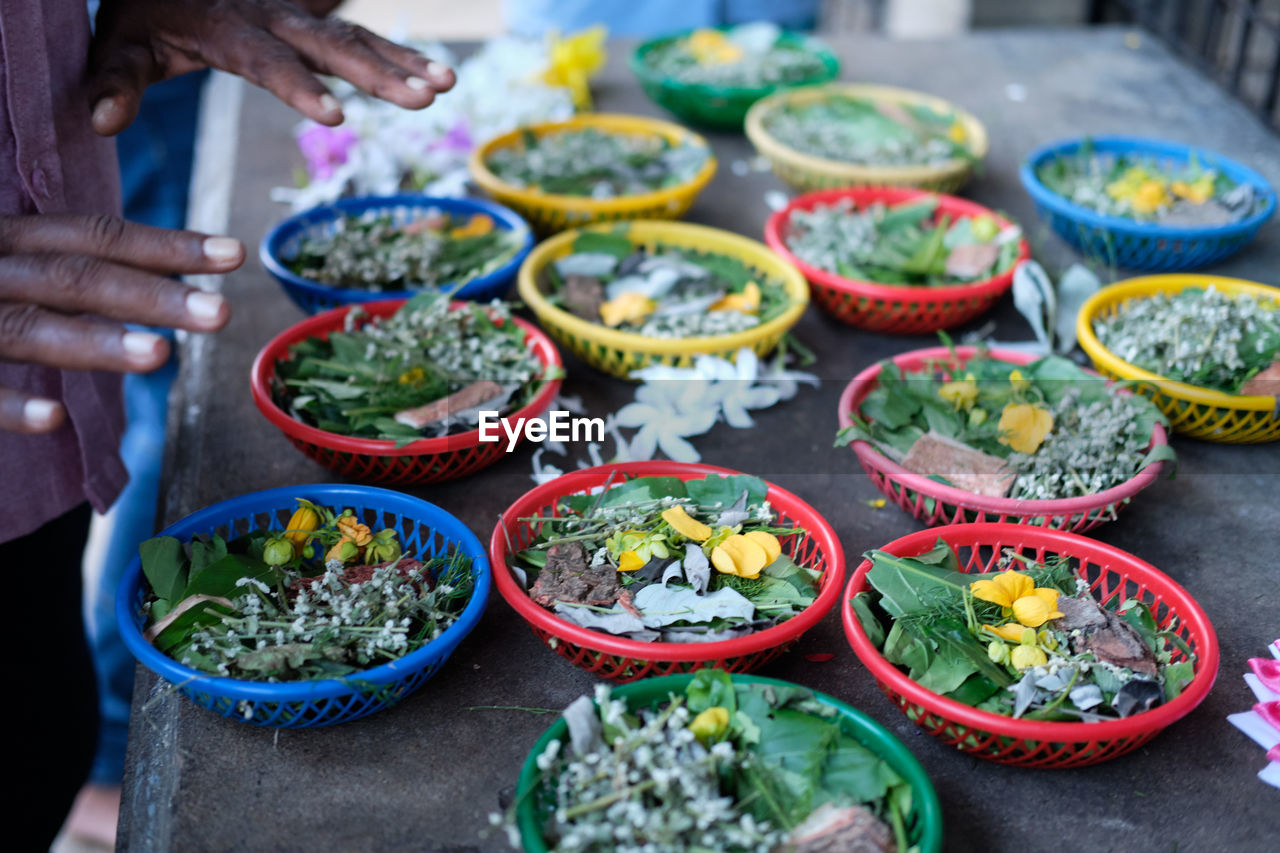 High angle view of hands over religious offerings for sale at market