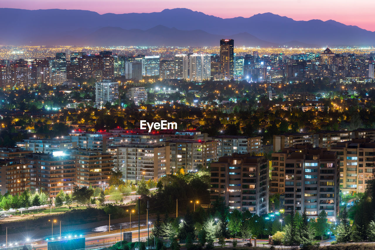 High angle view of illuminated buildings in city at dusk