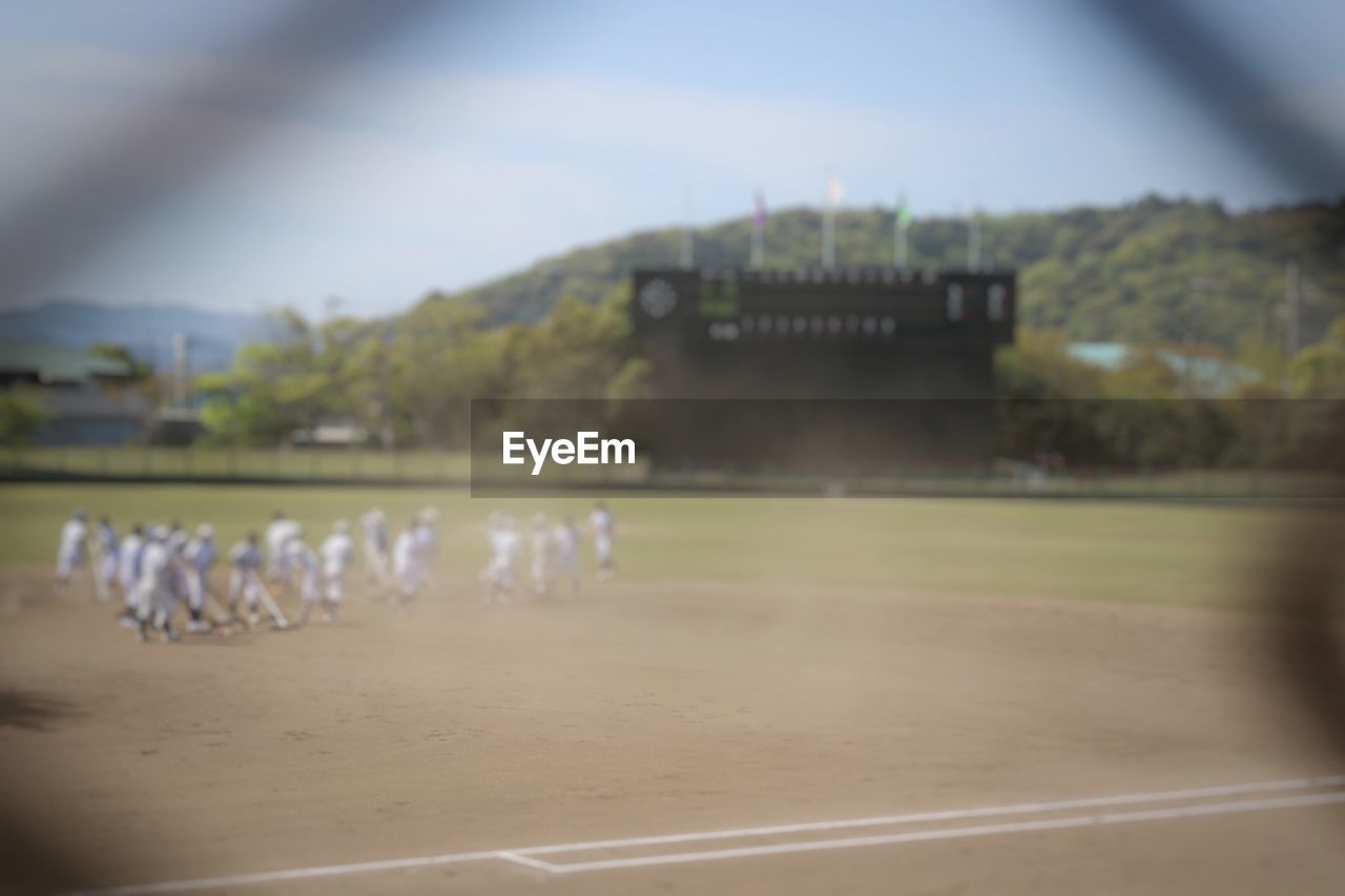 Defocused image of people playing baseball on field