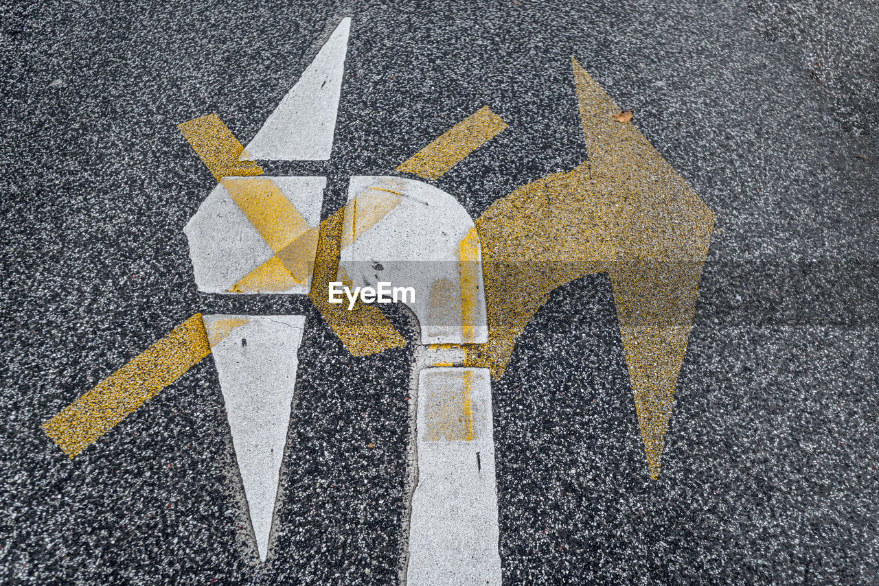 Close-up of yellow arrow symbols on road