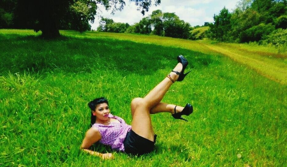 GIRL RELAXING ON GRASSY FIELD IN PARK