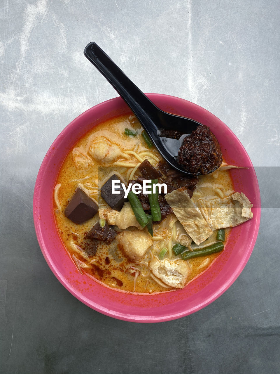 Close up view of a bowl of curry noodles or locally named curry mee. it is a special penang delicacy