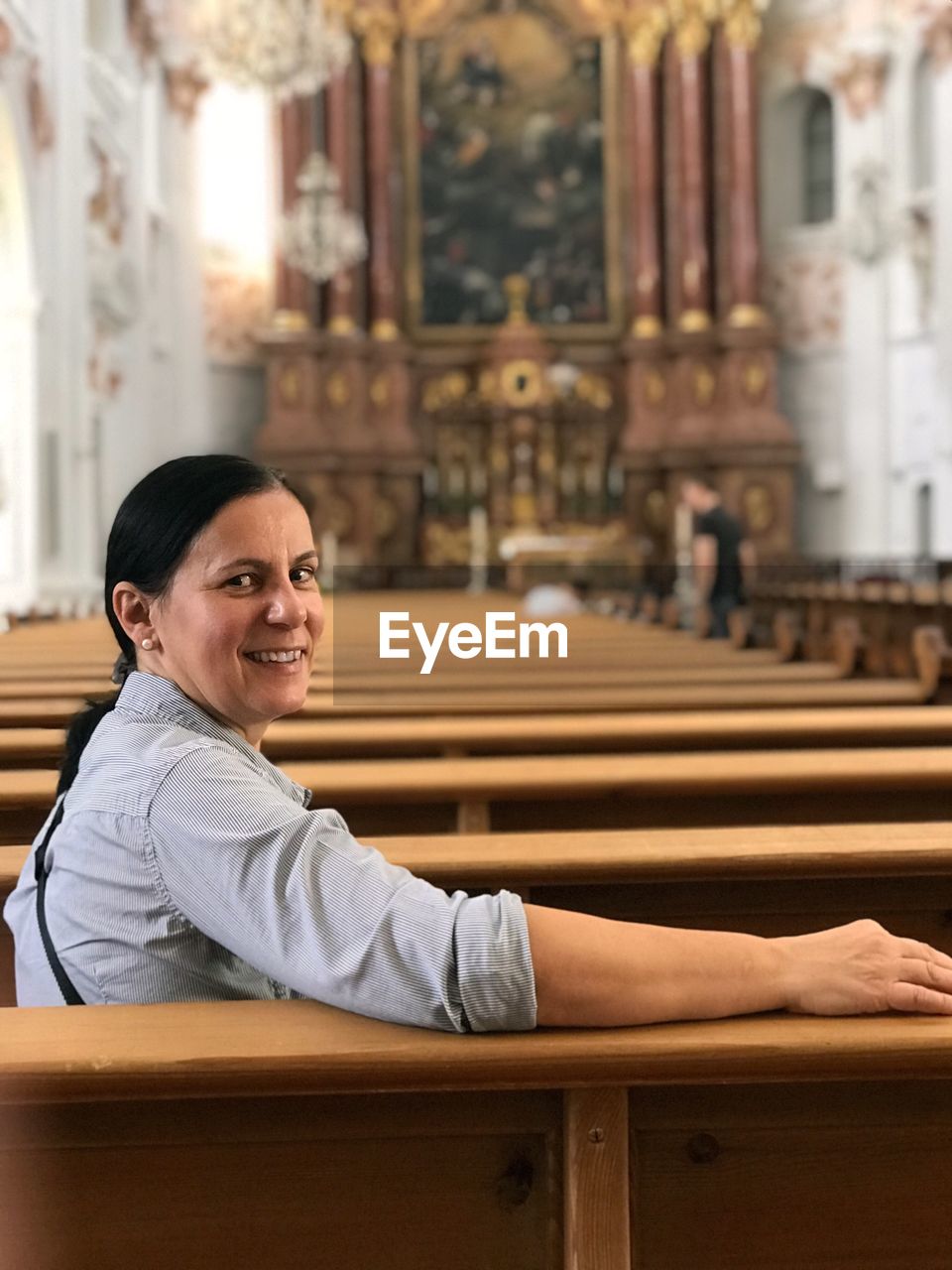 Portrait of smiling woman sitting in pew