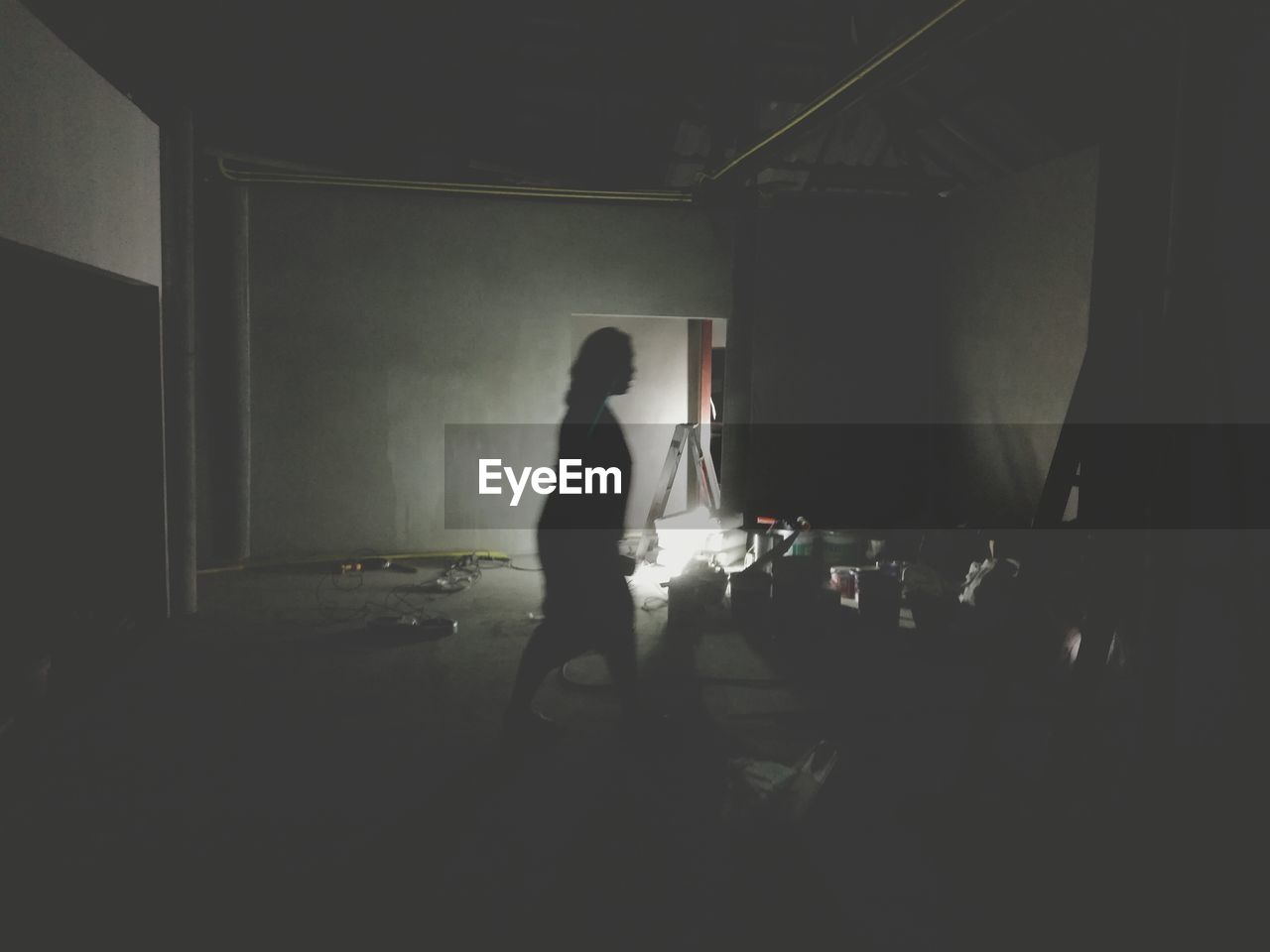 FULL LENGTH OF MAN STANDING IN CORRIDOR OF BUILDING