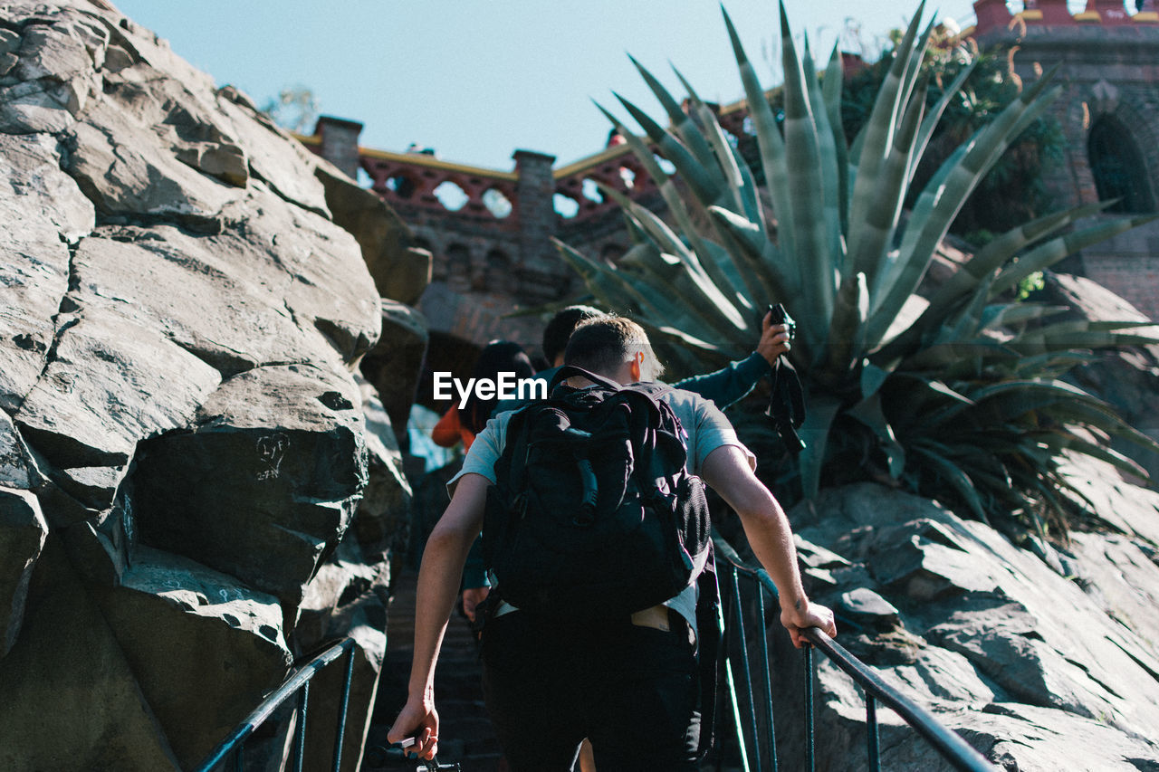 Rear view of young man moving on steps amidst rocky mountains