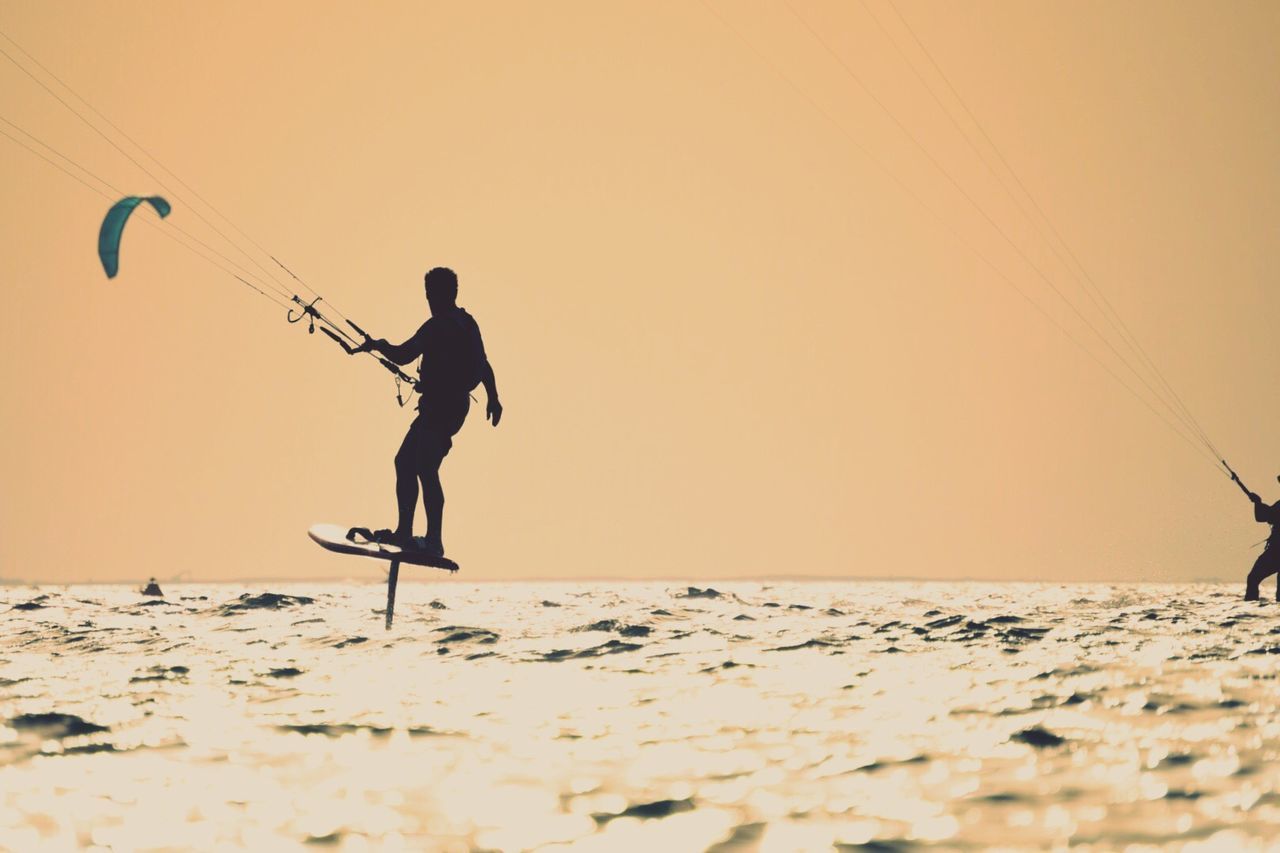 Silhouette of person kiteboarding