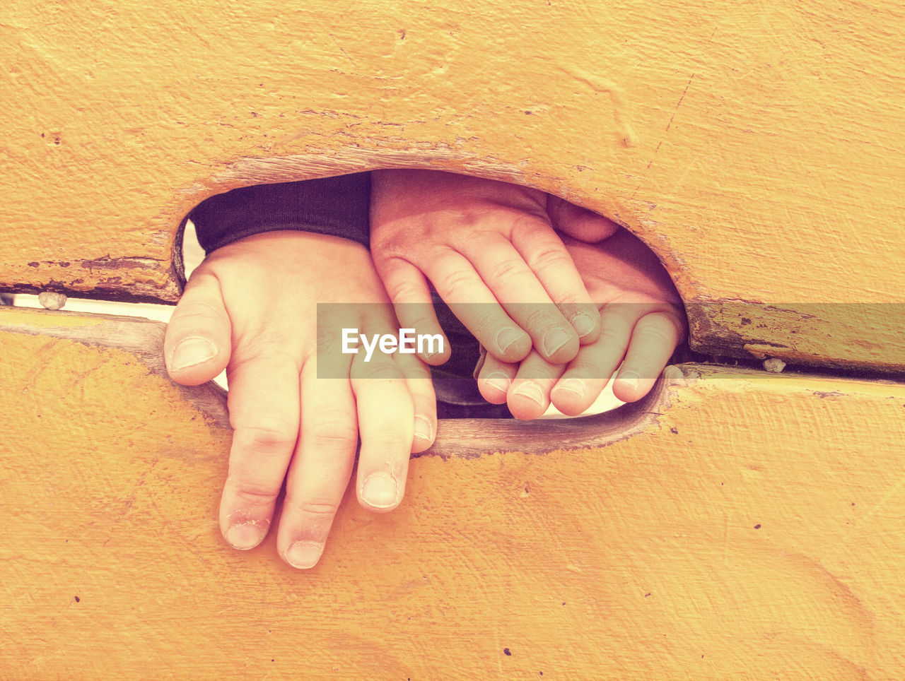 Kid climbing hand in hole of outdoor climbing wooden wall. selective focus on the hand.