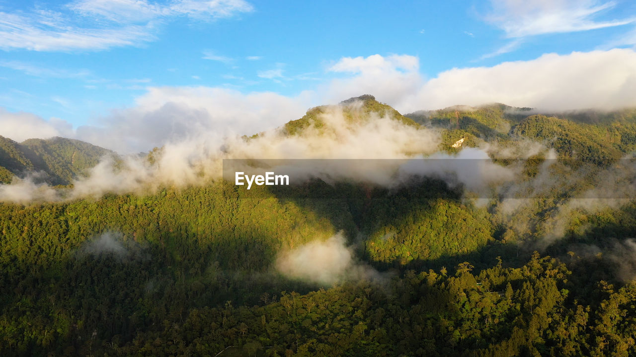 Aerial view of sunrise in the mountains covered with rainforest with clouds. philippines, mindanao.