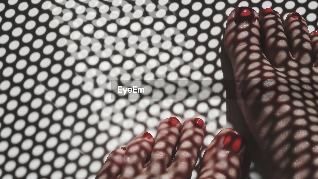 Low section of woman with red nail polish standing on floor