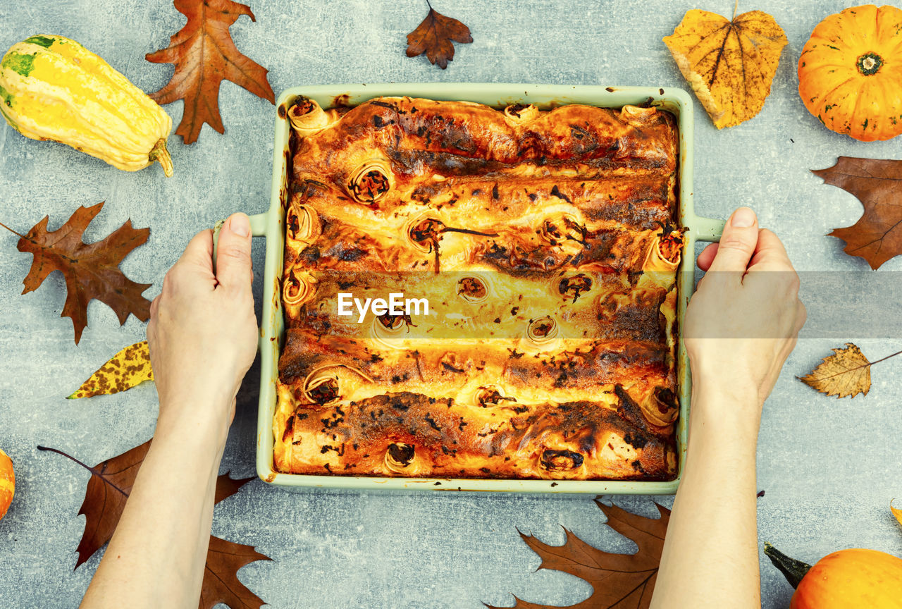 Pumpkin baked with cottage cheese in pita bread, appetizing autumn tart in hands
