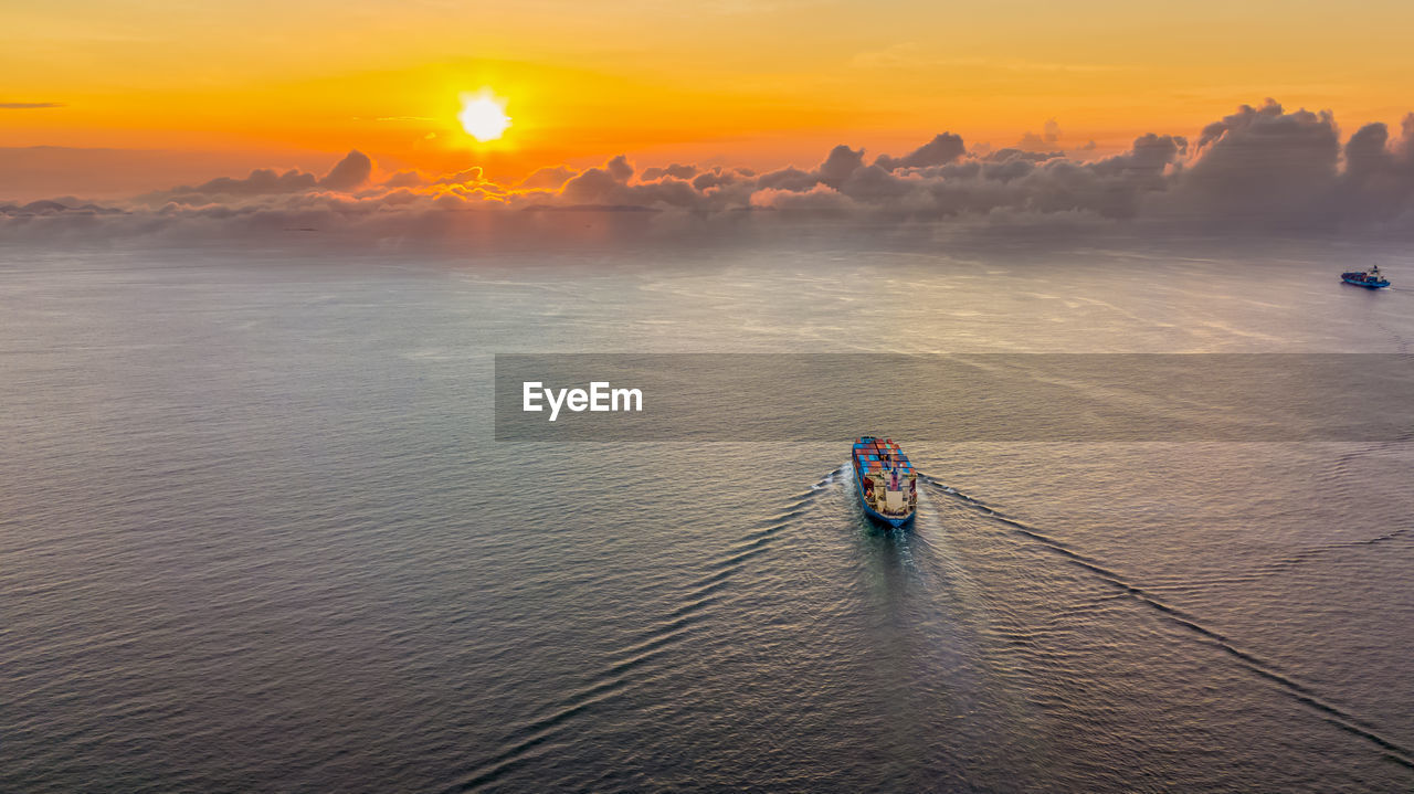 High angle view of boat sailing in sea during sunset