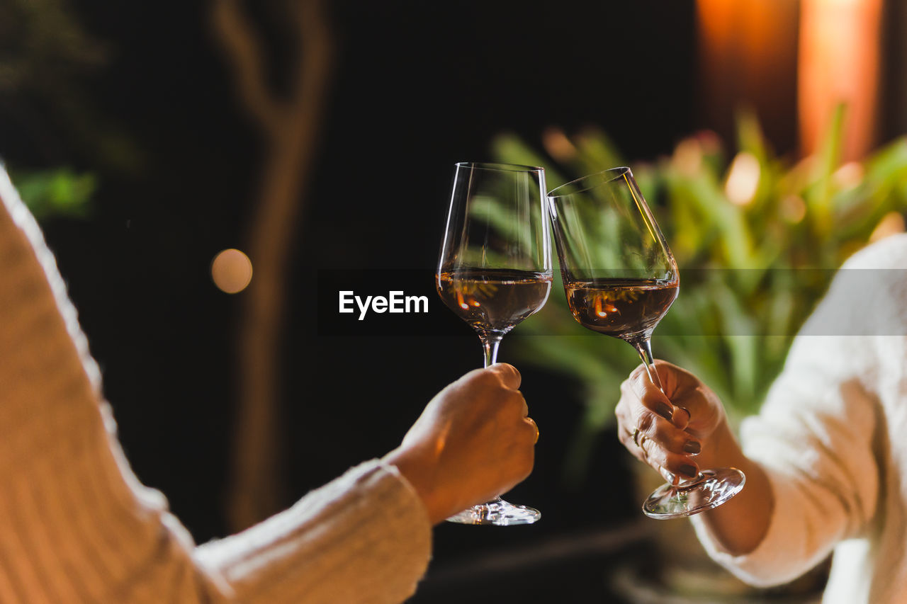 Woman hand clicking glasses of wine celebration concept.