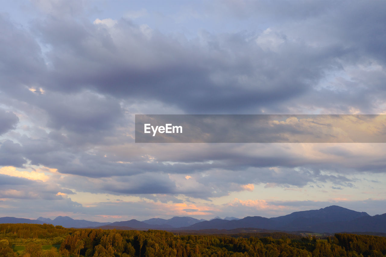 sky, cloud, environment, landscape, beauty in nature, scenics - nature, mountain, nature, horizon, plant, land, no people, mountain range, prairie, tranquility, dramatic sky, morning, grassland, plain, tree, tranquil scene, non-urban scene, field, outdoors, dawn, rural scene, sunlight, horizon over land, grass, travel destinations, day, cloudscape, travel, yellow, multi colored, blue, forest, idyllic, copy space, meadow