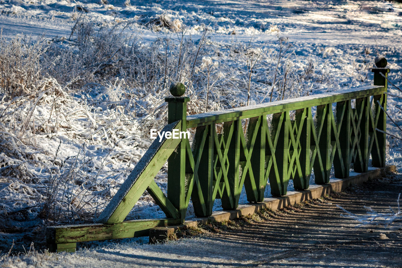 Wooden walkway amidst snowy field