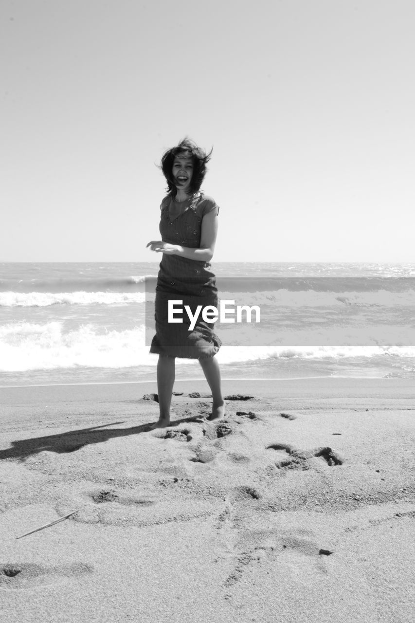 FULL LENGTH OF MAN STANDING ON BEACH